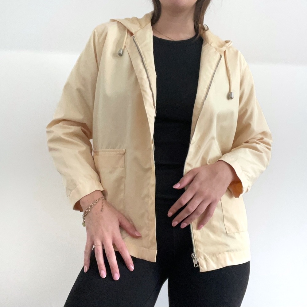Pale yellow 90s-style hooded zip-up windbreaker